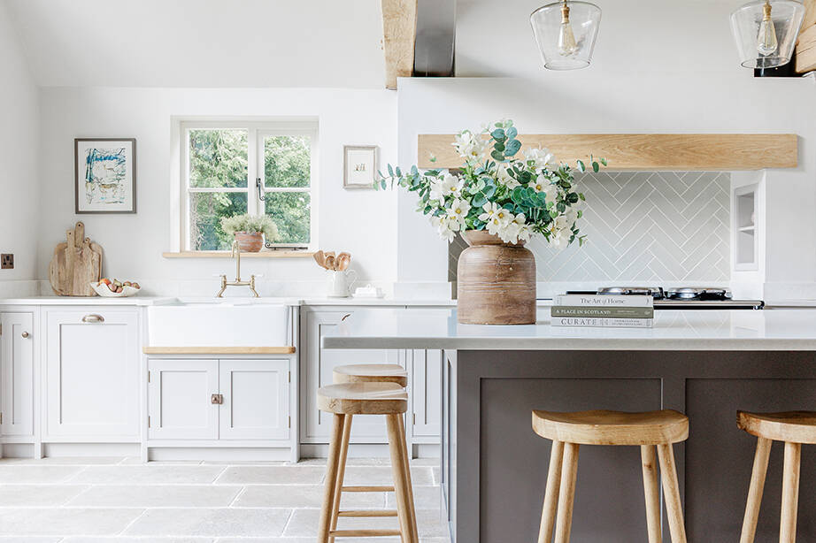 Clermont Gris Aged Tumbled Limestone Floor Tiles in an open kitchen with a grey island and wooden stools