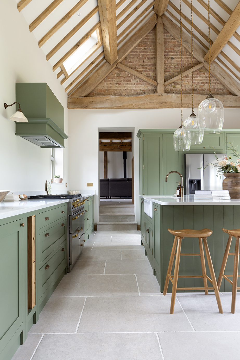 Versailles Softly Aged Limestone Kitchen Flooring featuring green vanity units and wooden stools